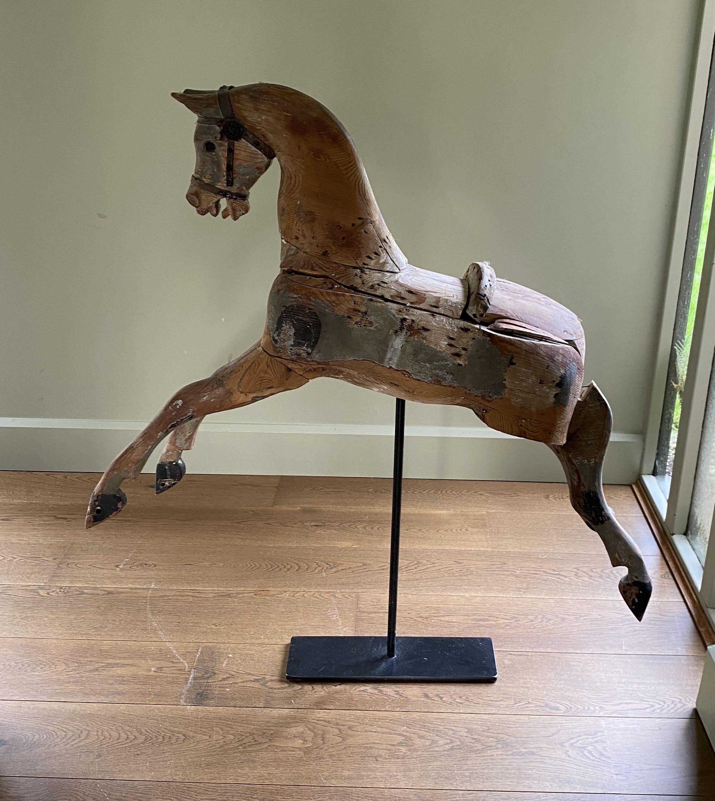 A Victorian painted pine rocking horse, now on wrought iron stand, length 96cm height including stand 108cm